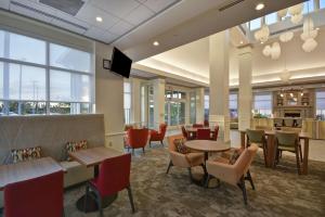 a restaurant with tables and chairs and a tv at Hilton Garden Inn Panama City in Panama City