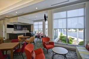 a lobby with tables and chairs and a large window at Hilton Garden Inn Panama City in Panama City