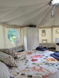 1 dormitorio con 1 cama grande en una tienda de campaña en Luxury Glamping @Moulin des Forges, en Moutier-Malcard