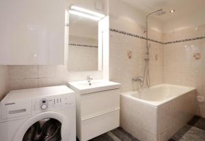 a white bathroom with a washing machine and a sink at Apartment near the Charles Bridge in Prague