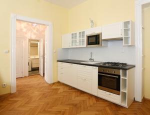 cocina con armarios blancos y fogones en Apartment near the Charles Bridge, en Praga
