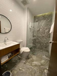 a bathroom with a toilet and a sink and a shower at Clay Hotel Udonthani in Udon Thani