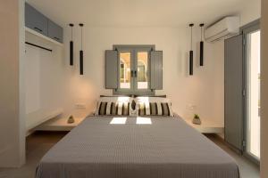 フィラにあるLinea Luxury Suitesのベッドルーム(ベッド1台、鏡付)