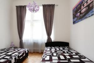 Un dormitorio con una cama y una ventana con una lámpara de araña. en Apartment near the Charles Bridge, en Praga