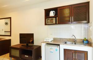 a kitchen with a sink and a tv on a counter at Phuket Riviera Villas - SHA Extra Plus in Nai Harn Beach