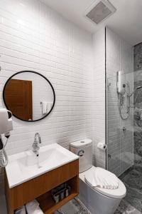 a bathroom with a sink and a toilet and a mirror at Clay Hotel Udonthani in Udon Thani