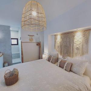 um quarto com uma cama grande e um lustre em B&B Sara Sueño em Málaga