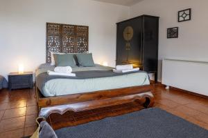 1 dormitorio con 1 cama grande de madera y toallas. en Casa Rural La Goleta, en San Martín de Valdeiglesias