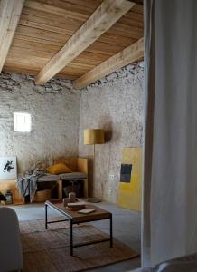 a living room with a table and a bed at CAN TAT, Loft in a old coach house in Sant Jordi Desvalls