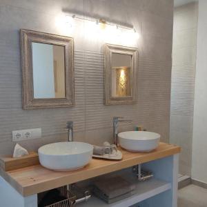 two sinks in a bathroom with two mirrors at B&B Sara Sueño in Málaga