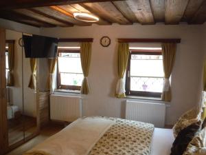 een slaapkamer met een bed en 2 ramen bij Ferienwohnung Weberlenz in Gmünd in Kärnten