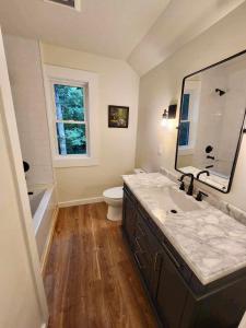 a bathroom with a sink and a toilet and a mirror at Sliding Rock -A Creekside Cottage w7 acres, Waterfalls & Hiking in Old Fort
