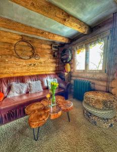 - un salon avec un canapé en cuir et une table dans l'établissement Casutele din Livada, à Corbi