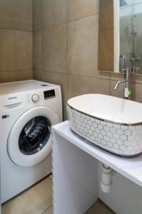 a bathroom with a washing machine and a sink at Garden Apartment in Split