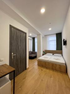 a bedroom with a large bed and a wooden floor at Hotel mia Telavi in Tʼelavi