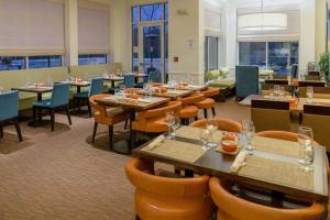 uma sala de jantar com mesas e cadeiras num restaurante em Hilton Garden Inn Kennett Square em Kennett Square