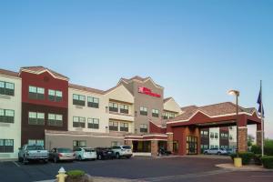 a hotel with cars parked in front of a parking lot at Hilton Garden Inn Phoenix Airport in Phoenix