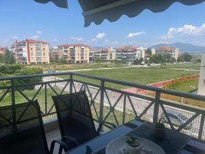 a balcony with a table and chairs and buildings at Kalliopi Deluxe Apartment in Perea