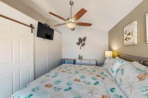 a bedroom with a bed and a ceiling fan at Madeira Beach Yacht Club #G in St. Pete Beach