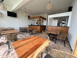 a dining room with wooden tables and chairs at Nikoli Apartments in Benitses