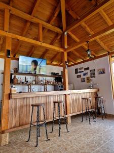 a bar with stools in a room with wooden ceilings at Agapia Agapescu in Agapia