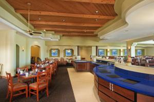 a restaurant with wooden ceilings and tables and chairs at Hilton Phoenix Airport in Phoenix