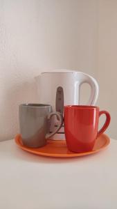 three coffee cups on a plate on a shelf at Almasarda in Olbia