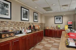 a kitchen with wooden cabinets and a brick wall at Hampton Inn & Suites Phoenix-Surprise in Surprise