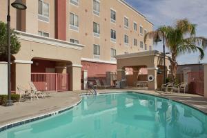 uma piscina em frente a um hotel com um edifício em Hampton Inn & Suites Phoenix-Surprise em Surprise