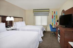 a hotel room with two beds and a flat screen tv at Hampton Inn & Suites Phoenix-Surprise in Surprise