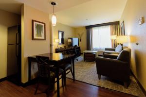 a living room with a table and a room with a couch at Homewood Suites by Hilton Phoenix Chandler Fashion Center in Chandler