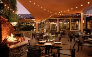 a restaurant with tables and chairs and a fire pit at Hilton Garden Inn Phoenix North Happy Valley in Phoenix