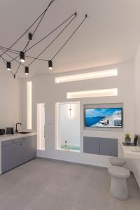 フィラにあるLinea Luxury Suitesの白いキッチン(壁に薄型テレビ付)