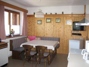 - une cuisine avec une table et des chaises dans la chambre dans l'établissement Appartement Hasenauer, à Hollersbach im Pinzgau