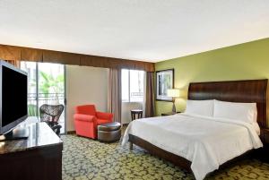 a hotel room with a bed and a flat screen tv at Hilton Garden Inn Phoenix Midtown in Phoenix