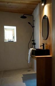a bathroom with a black sink and a mirror at CAN TAT, Loft in a old coach house in Sant Jordi Desvalls +20 photos