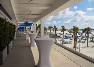 a row of white tables on a balcony with the beach at Hilton Clearwater Beach Resort & Spa in Clearwater Beach