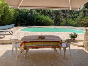 een tafel en stoelen voor het zwembad bij Superbe T2 dans villa entre calanques et colline in Marseille