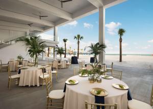 un restaurant avec des tables et des chaises ainsi qu'une plage dans l'établissement Hilton Clearwater Beach Resort & Spa, à Clearwater Beach