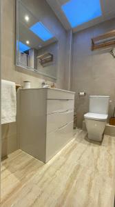 een badkamer met een toilet, een wastafel en een spiegel bij Cal Xambu in Cambrils