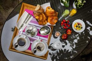 uma mesa com uma bandeja de produtos de pastelaria e chávenas de café em La Villa Madame em Paris
