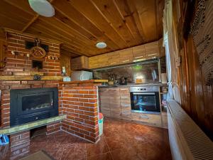a kitchen with a brick fireplace and a stove at Златкова къща in Koprivshtitsa