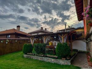 a patio with a table and a bridge in a yard at Златкова къща in Koprivshtitsa +46 photos