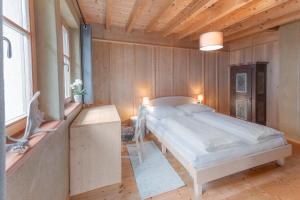 a bedroom with a bed in a room with wooden walls at Eco Chalet Olival in Braies