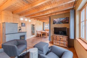 a living room with a tv and a couch at Eco Chalet Olival in Braies