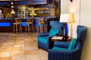 un bar avec des chaises bleues et une table avec une lampe dans l'établissement DoubleTree by Hilton Portland, ME, à South Portland