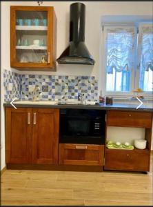 una cucina con armadi in legno e forno a microonde nero di Oasi Felice a Vietri