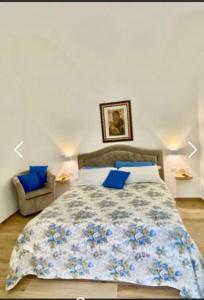una camera da letto con un grande letto con cuscini blu di Oasi Felice a Vietri