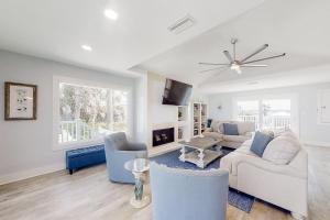 sala de estar con sofá, sillas y TV en Oceanfront Oasis, en Crescent Beach