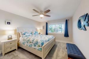 1 dormitorio con 1 cama y ventilador de techo en Oceanfront Oasis, en Crescent Beach